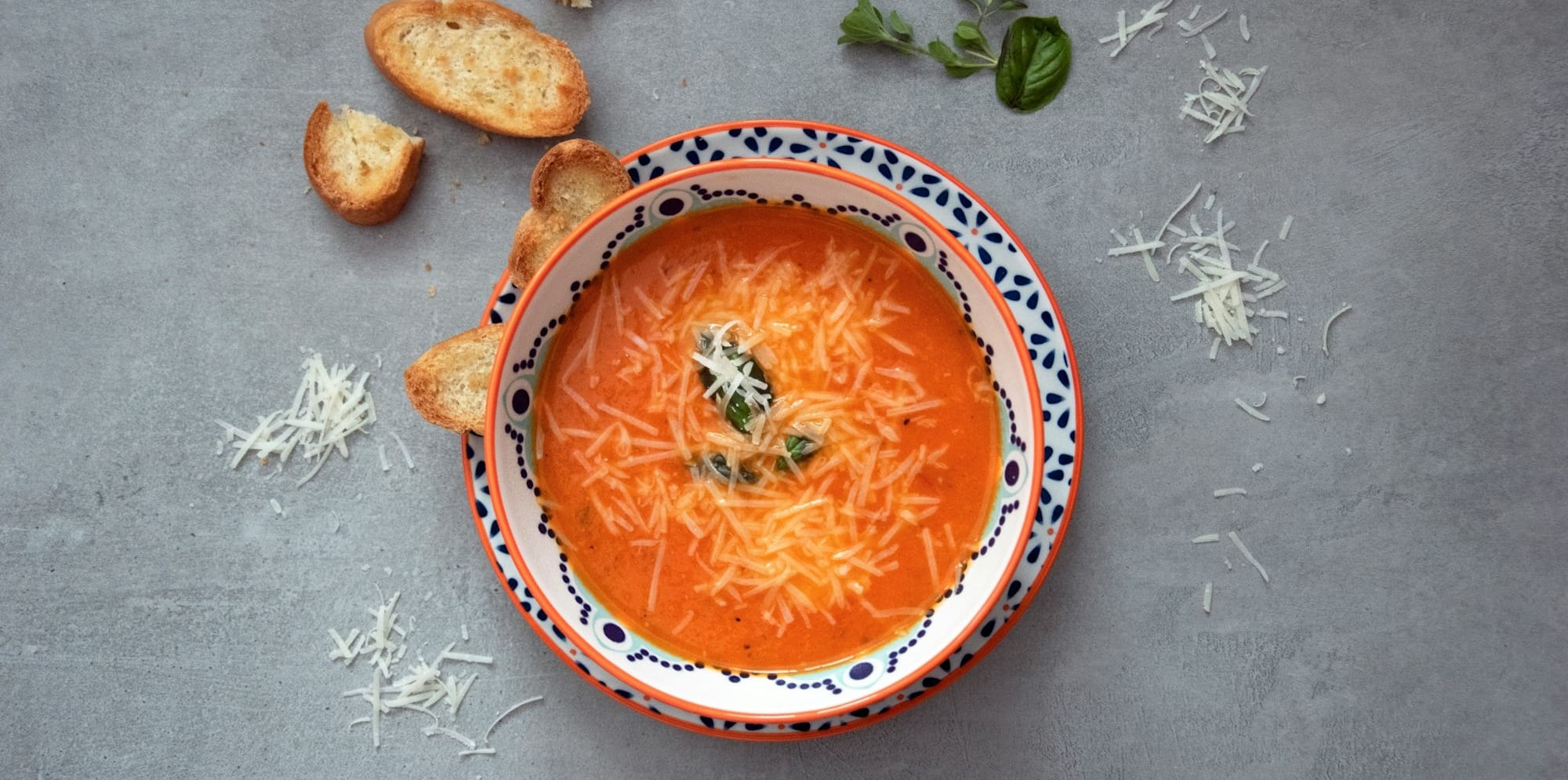 orange soup on white and blue ceramic bowl