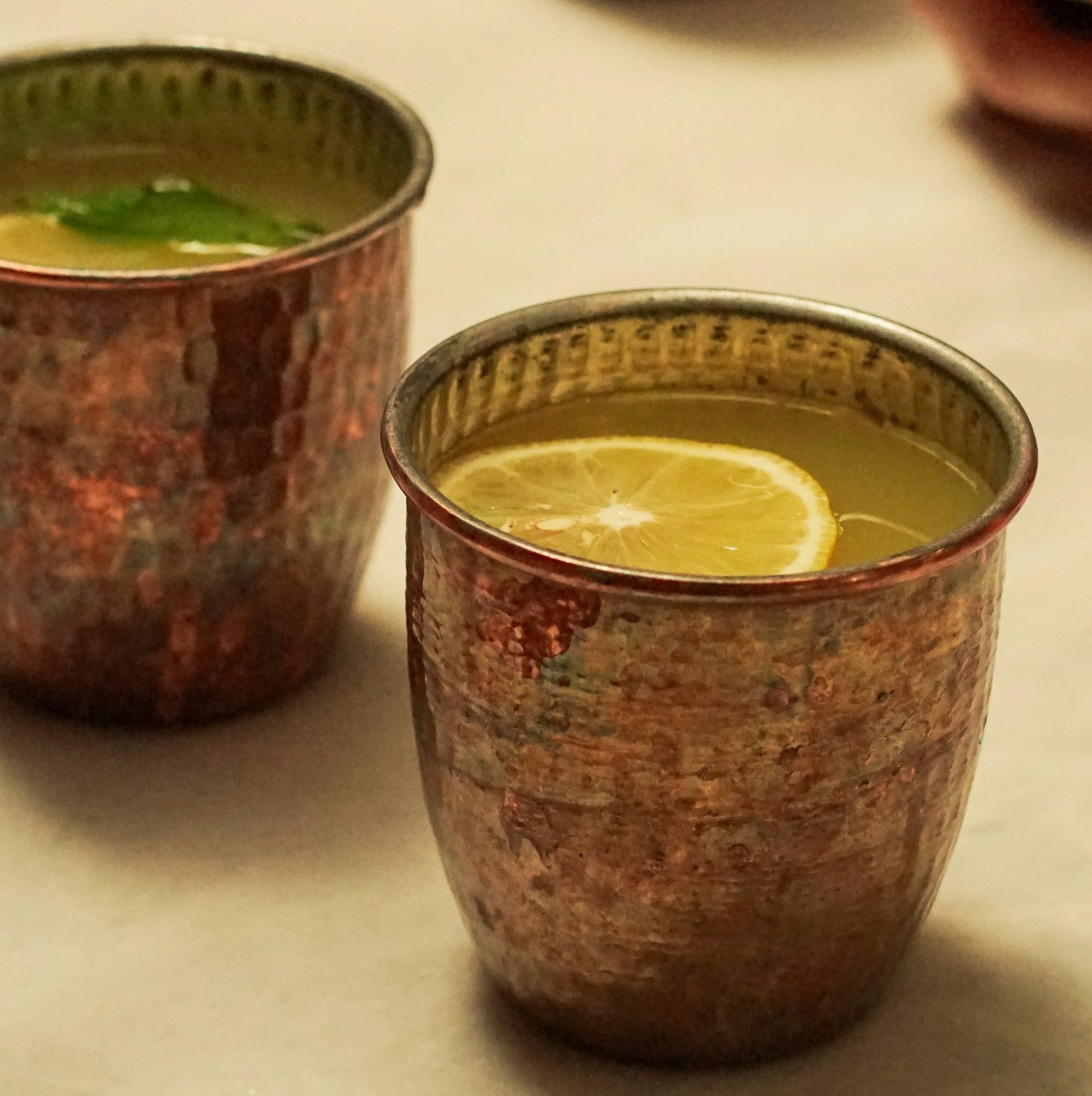 a table topped with two cups filled with liquid