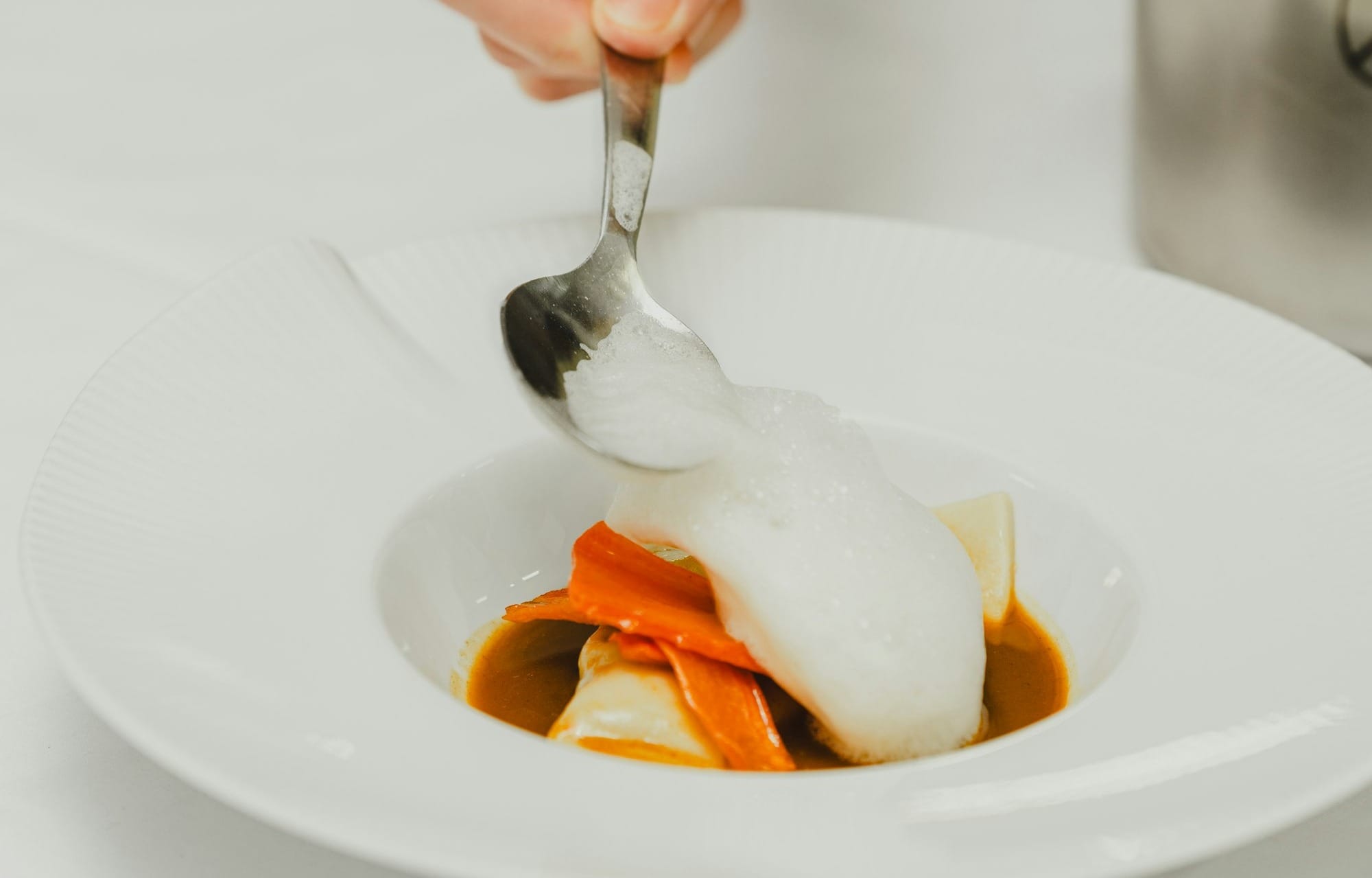 a person with a spoon in a bowl of food